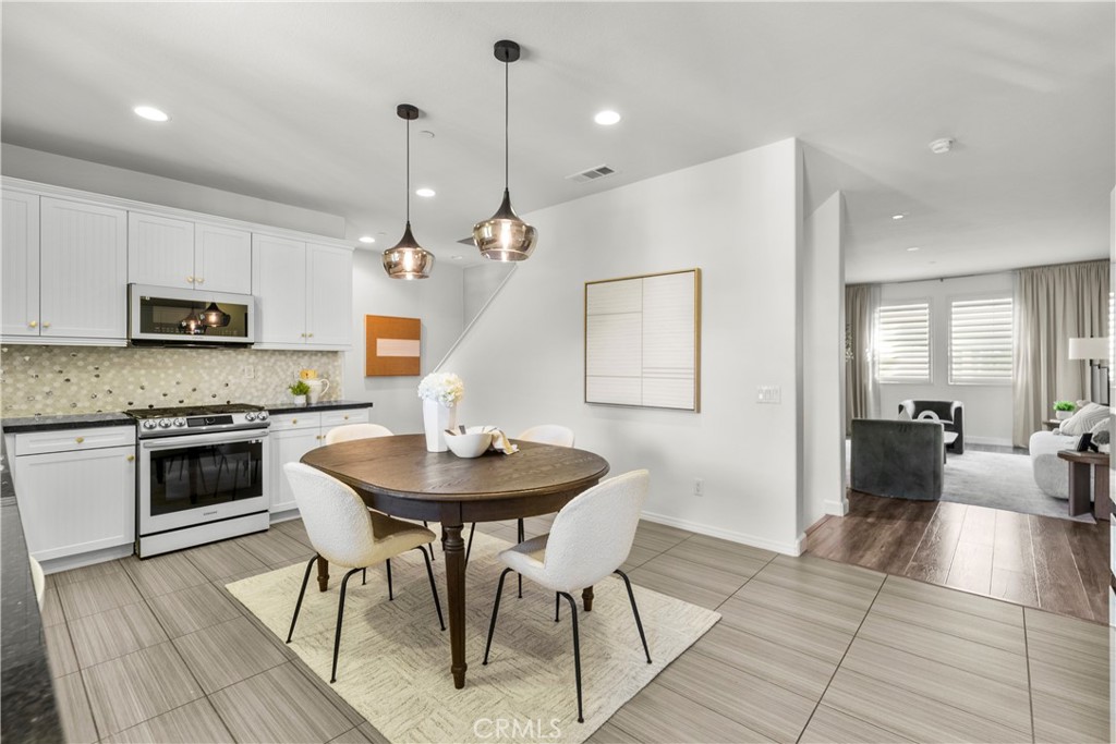 22157 Barrington Way Saugus, CA 91350 - Photo 22 of 46 a kitchen with sink cabinets dining table and chairs