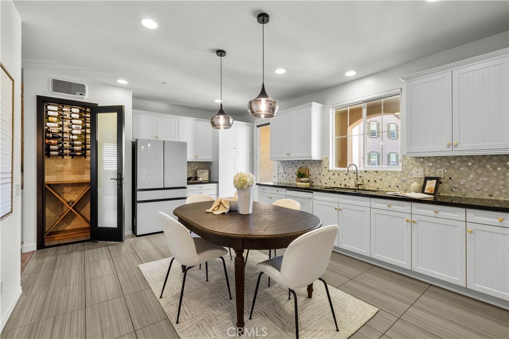 22157 Barrington Way Saugus, CA 91350 - Photo 23 of 46 a kitchen with stainless steel appliances kitchen island granite countertop a stove a refrigerator a sink a dining table and chairs with wooden floor