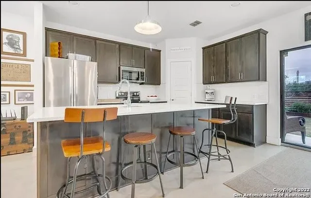 a kitchen with stainless steel appliances granite countertop a sink a stove and a refrigerator