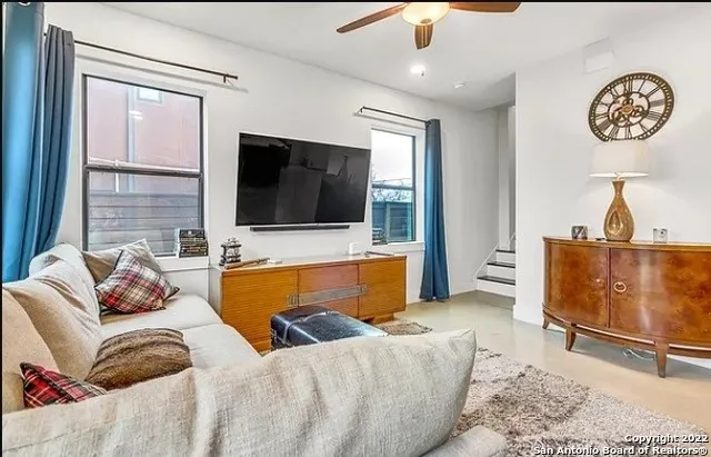 a living room with furniture a large window and a flat screen tv