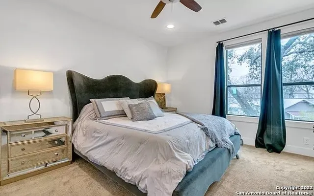 a bedroom with a large bed and a chandelier