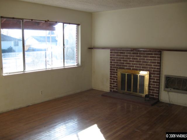 1285 Trainer Way Reno, NV 89512 - Photo 6 of 9 an empty room with wooden floor and fireplace