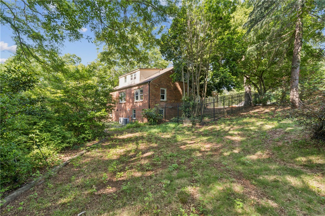 321 South Pine Street Walhalla, SC 29691 - Photo 32 of 32 Mature trees and lush greenery provide a secluded setting for this brick-clad residence.