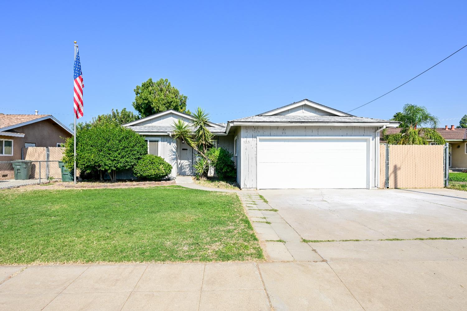 133 10th Street Clovis, CA 93612 - Photo 1 of 17 a front view of a house with a yard and garage