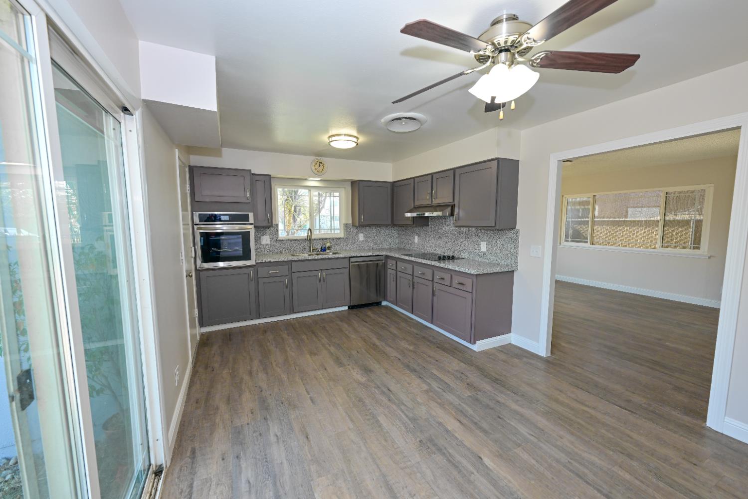 133 10th Street Clovis, CA 93612 - Photo 6 of 17 a kitchen with stainless steel appliances granite countertop a refrigerator a sink dishwasher a stove with wooden floor and cabinets