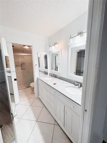 a bathroom with a double vanity sink mirror and bathtub