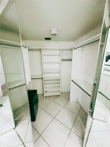 a view of walk in closet with empty racks