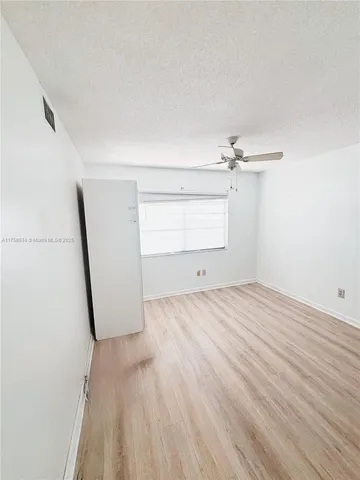 a view of a room with wooden floor and white walls