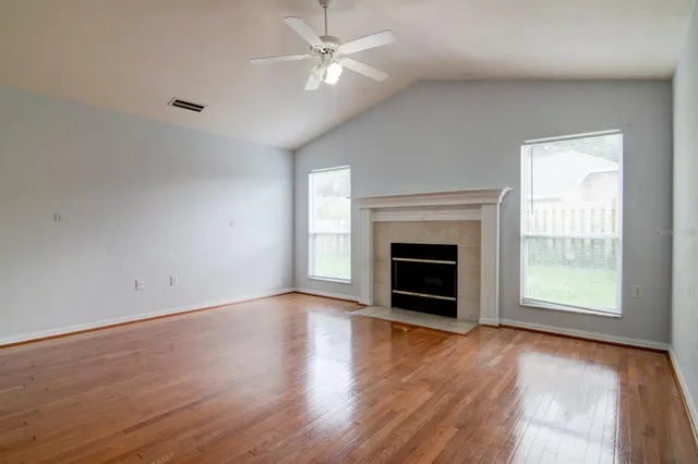 wooden floor fireplace and windows in an empty room