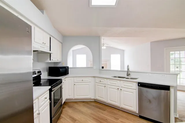 a kitchen with granite countertop white cabinets and white appliances