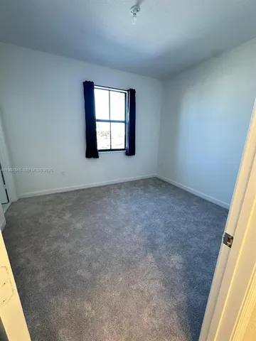 a view of a house with a yard and a bench