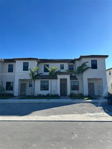 a view of a hallway to a house with stairs