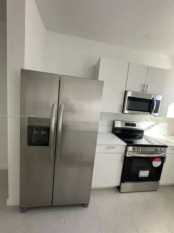 a kitchen with refrigerator and furniture