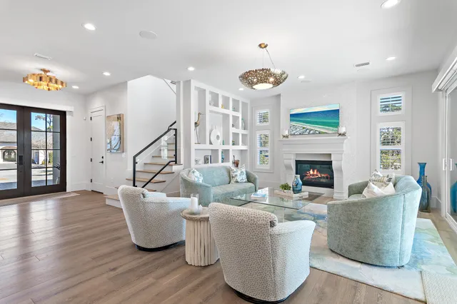 a living room with furniture a fireplace and a chandelier
