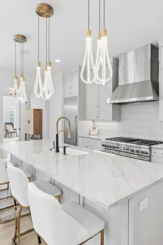 a kitchen with stainless steel appliances granite countertop a sink a stove and a wooden floors