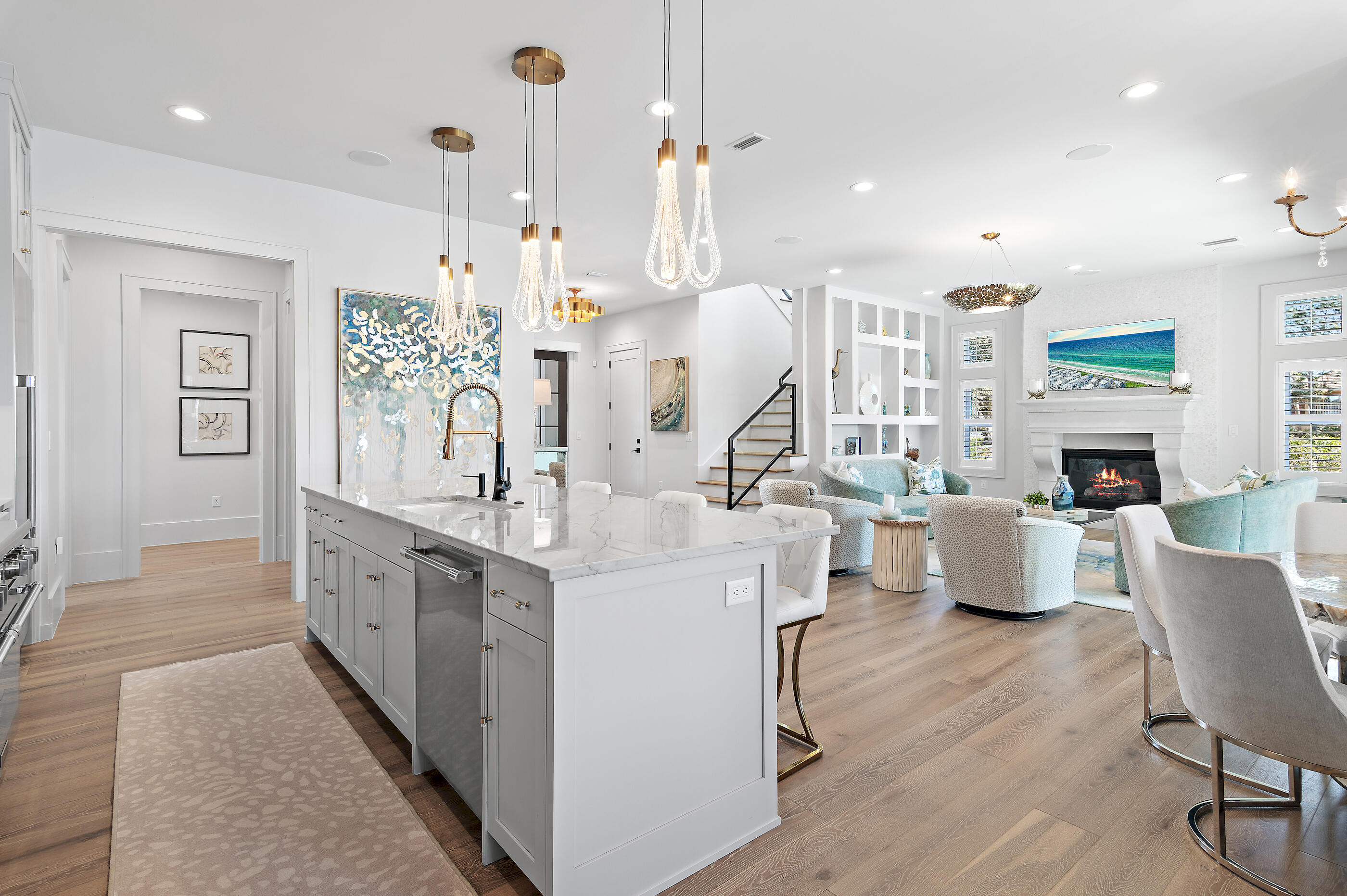 4572 Sailmaker Lane Destin, FL 32541 - Photo 17 of 49 a large white kitchen with a large island oven a sink dishwasher a dining table and chairs with wooden floor