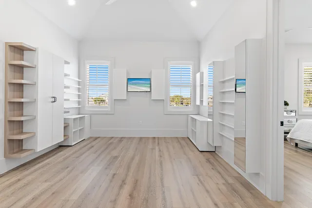 a view of hallway with wooden floor and windows