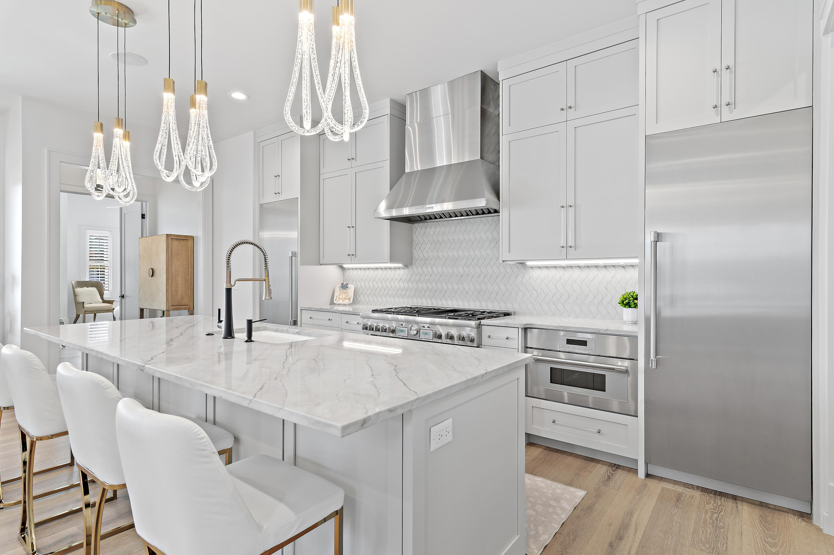 4572 Sailmaker Lane Destin, FL 32541 - Photo 4 of 49 a kitchen with white cabinets and stainless steel appliances