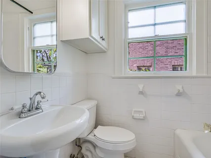 a white toilet sitting next to a bathroom sink