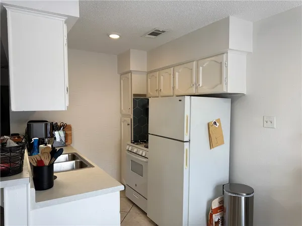 a kitchen with refrigerator a sink and cabinets