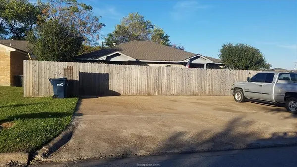 a view of backyard space and car parked