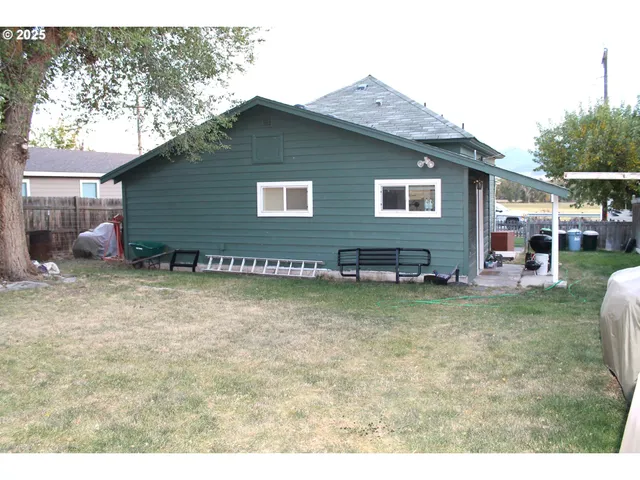 a view of a backyard with table and chairs and wooden fence