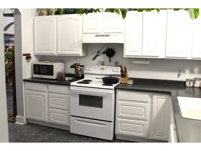a kitchen with white cabinets and white appliances