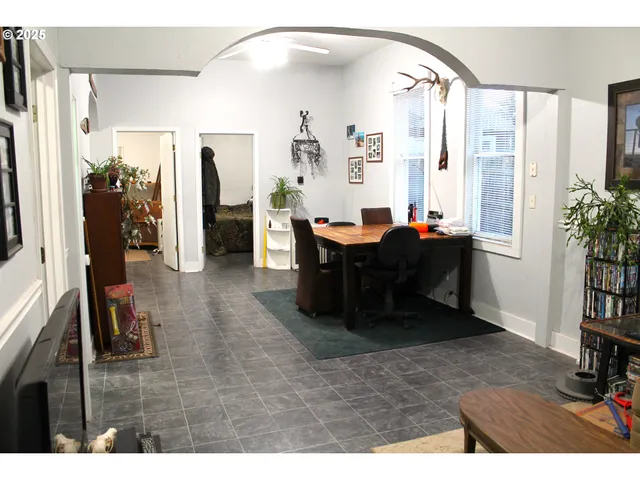 a living room with furniture a bookshelf and a window