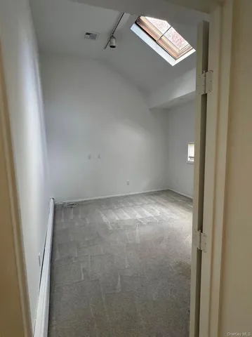 an empty room with windows and ceiling fan