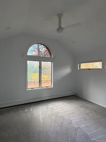 an empty room with a window and fireplace