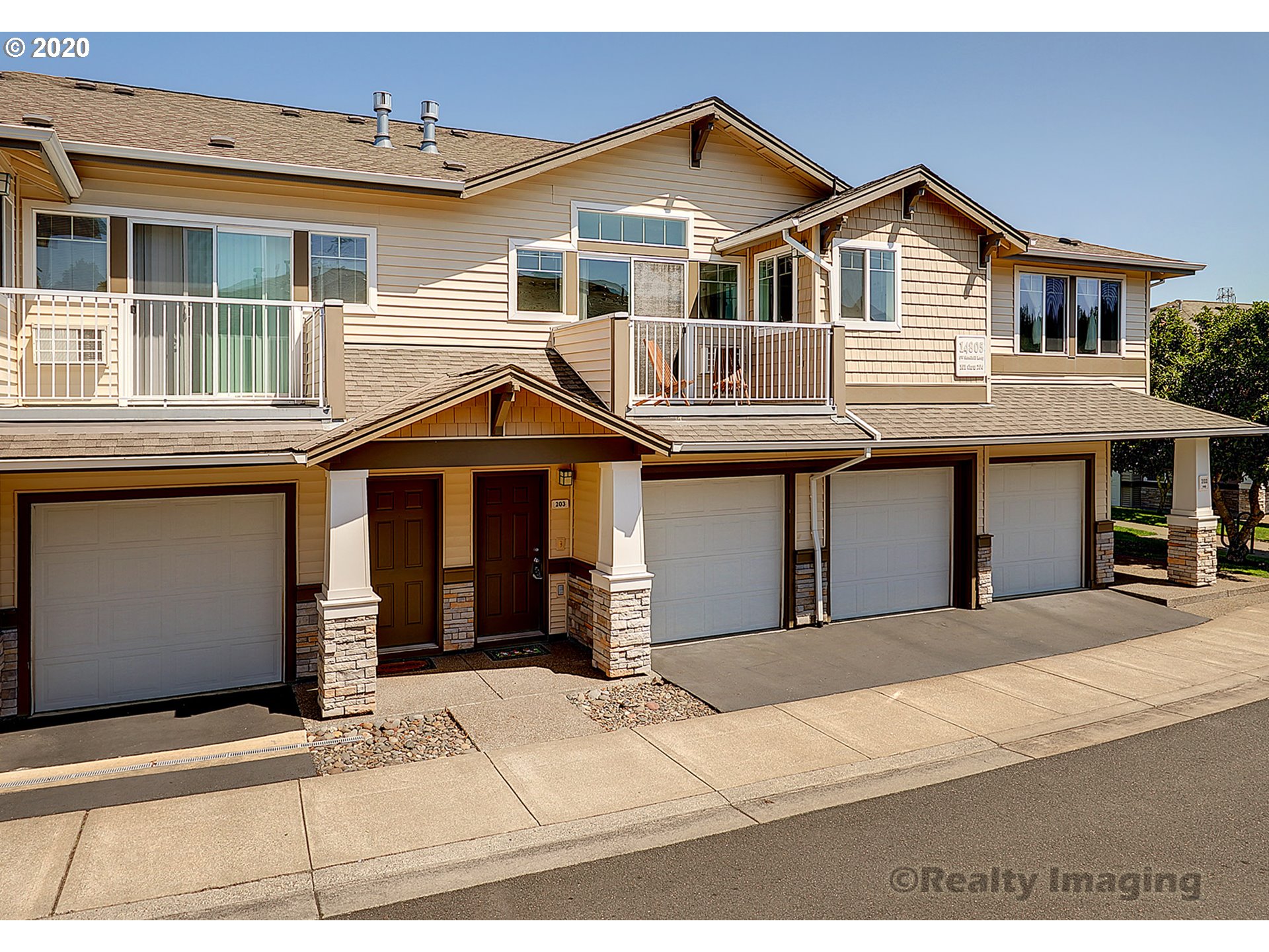 14805 Southwest Sandhill Loop, Unit 203 Beaverton, OR 97007 - Photo 1 of 20 a front view of a house with a yard and garage