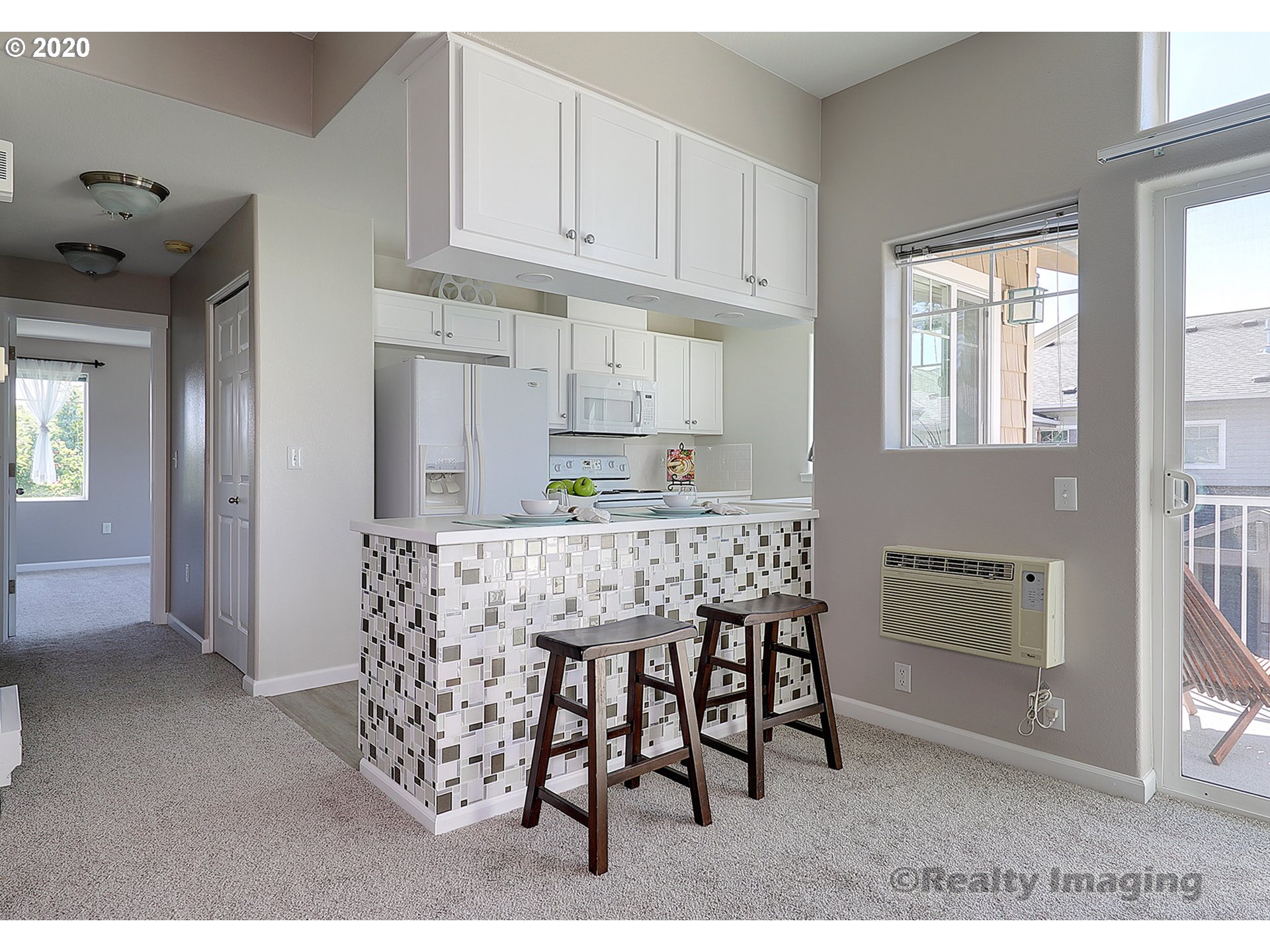 14805 Southwest Sandhill Loop, Unit 203 Beaverton, OR 97007 - Photo 4 of 20 a kitchen with stainless steel appliances kitchen island granite countertop a refrigerator a stove a microwave oven with white cabinets and wooden floor