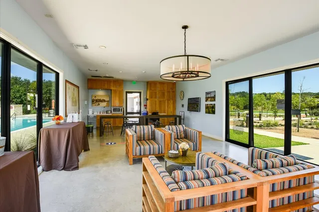 a living room with furniture a large window and chandelier