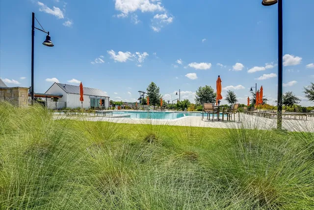 a swimming pool with outdoor seating and yard in back