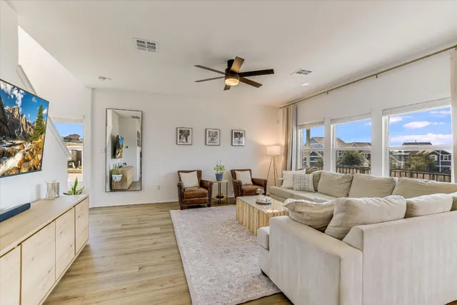 a living room with furniture large window and flat screen tv