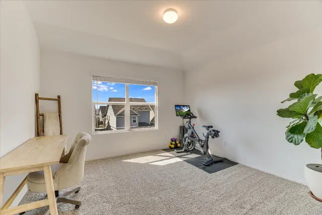a view of a workspace with furniture and a window