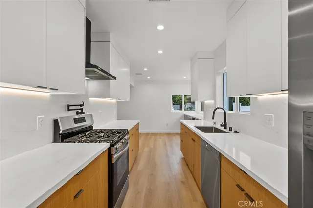 a kitchen with stainless steel appliances a sink stove and refrigerator