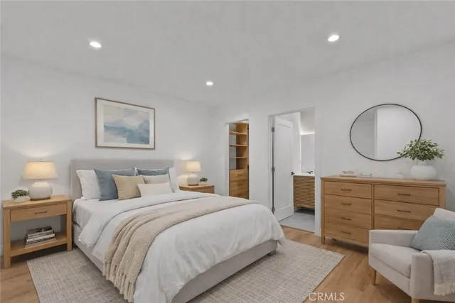 a bedroom with a bed a couches and a dresser