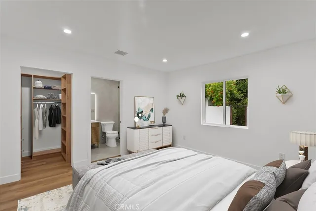 a bedroom with a bed and wooden floor