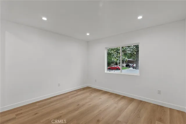 an empty room with wooden floor and entrance