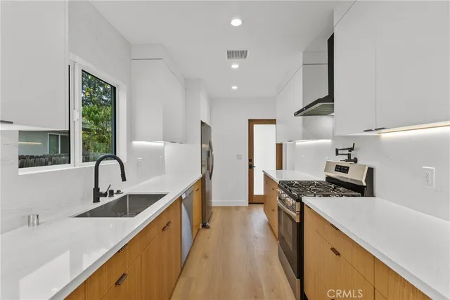 a kitchen with stainless steel appliances granite countertop a sink stove and refrigerator