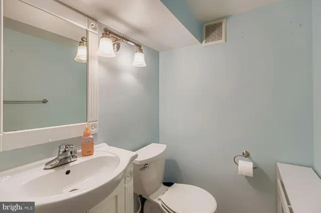 a bathroom with a sink mirror and toilet