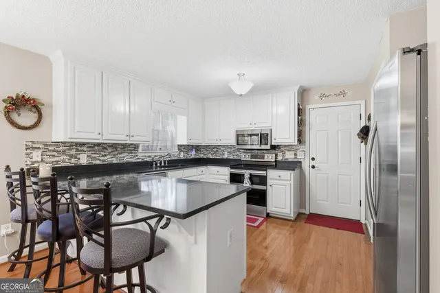 a kitchen with stainless steel appliances granite countertop a stove sink and cabinets