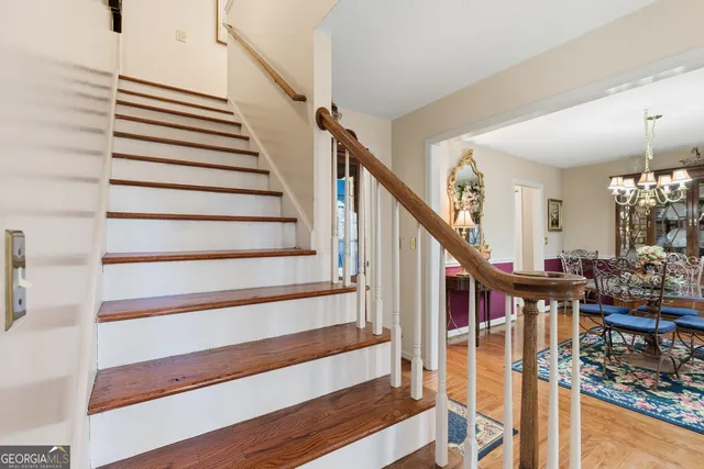 a spacious bedroom with a bed and a flat tv screen on the dresser