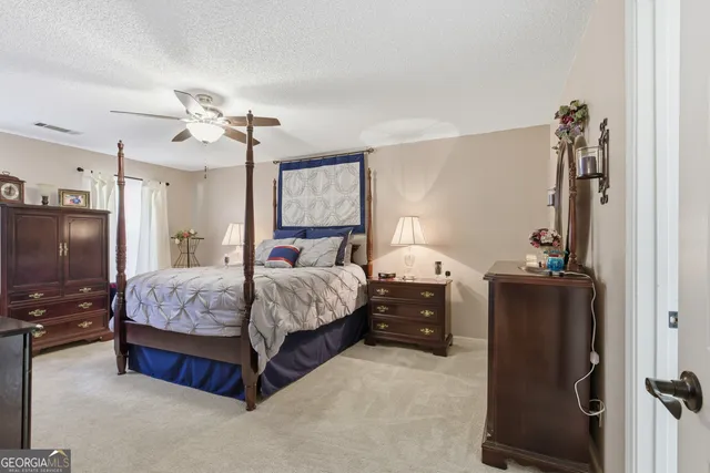 a bedroom with bed tv and a mirror