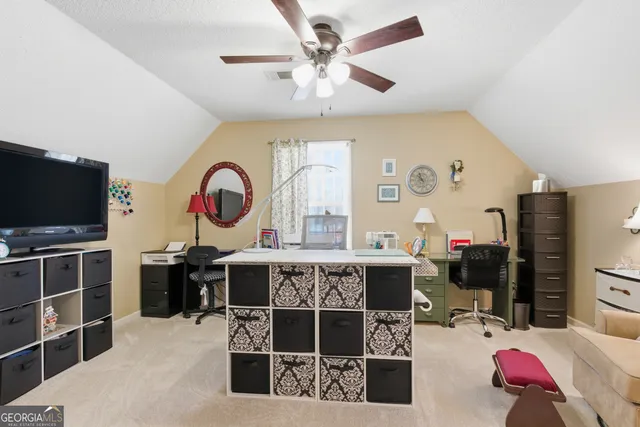 a view of a workspace with furniture and a ceiling fan