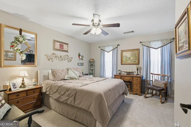 a bedroom with a bed and a flat tv screen on dresser