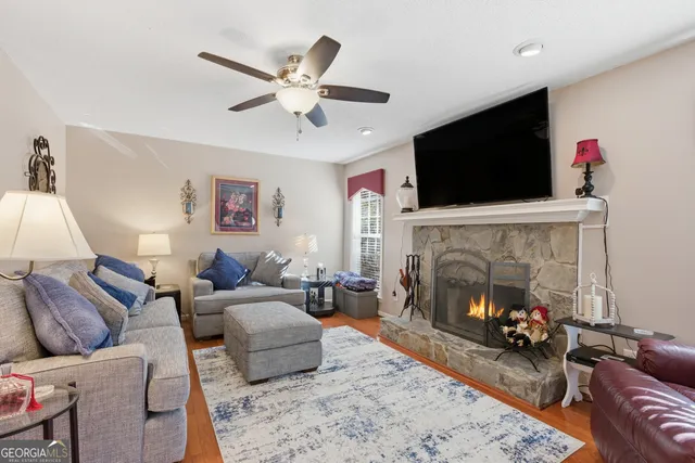 a living room with furniture kitchen view and a wooden floor