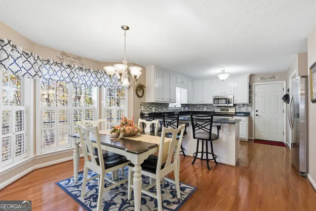 a kitchen with stainless steel appliances granite countertop a refrigerator a stove a sink and a stove with wooden floor