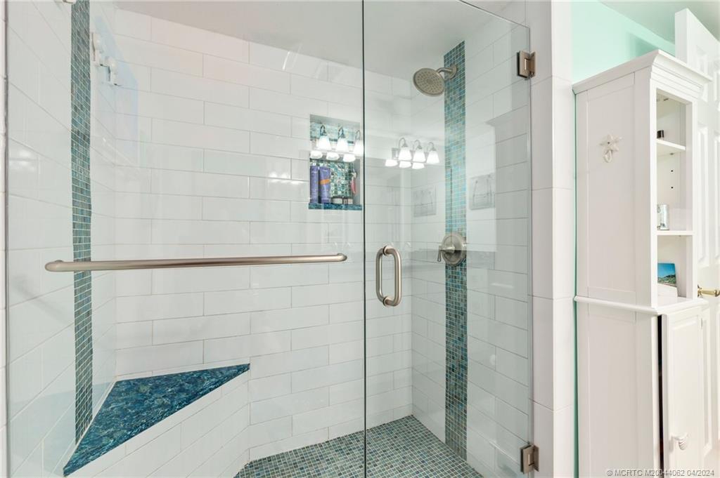 3135 Southeast Indian Street, Unit 5 Stuart, FL 34997 - Photo 28 of 41 a bathroom with a glass shower door